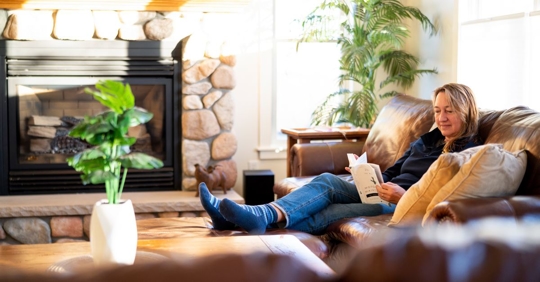 woman reading book on couch